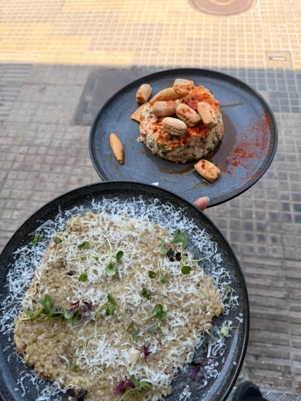Platos de risotto y ensaladilla servidos en terraza